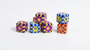 Detailed view of checkered cube beads with colorful floral patterns for DIY jewelry