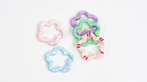 Macro view of flower-shaped alloy spring rings with colorful painted enamel patterns