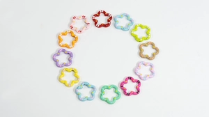 Flat lay of colorful flower-shaped alloy spring rings for DIY keychains in 12 vibrant colors