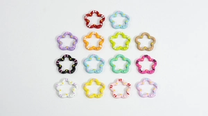 Close-up of 14 colorful flower shaped metal keyrings with spotted paint finish for DIY