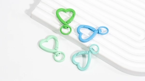 Dettaglio di moschettoni a cuore in colori pastello su un vassoio decorativo bianco