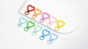 Dettaglio di dieci moschettoni colorati a forma di cuore con anelli girevoli a 360