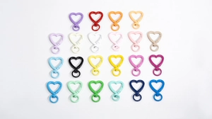 Dettaglio di moschettoni a forma di cuore colorati con basi girevoli per accessori fai-da-te