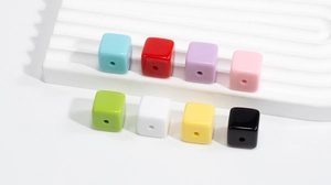 Close-up of vibrant acrylic cube beads in eight colors for DIY jewelry and crafts