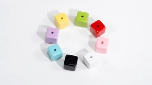 Close-up of colorful acrylic cube beads with center holes for DIY jewelry making and crafts