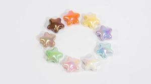 Vue macro de perles acryliques irisées en forme d'étoile avec trous latéraux pour DIY