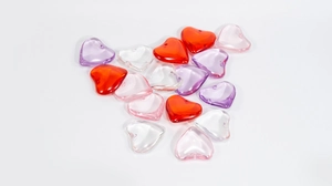 Close-up of heart-shaped acrylic resin beads in red pink purple and clear for DIY jewelry