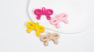 Close-up of colorful acrylic bow pendants with star charms for DIY jewelry making