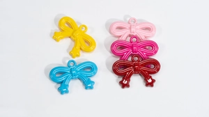 Close-up of colorful acrylic bow charms with glossy finish and star details for DIY jewelry