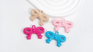 Macro detail of acrylic bow pendants in four colors for DIY jewelry and phone charms