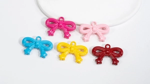 Close-up of colorful acrylic bow pendants in five glossy colors for DIY jewelry making