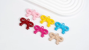 Detail of colorful acrylic bow pendants with glossy finish for DIY jewelry crafts