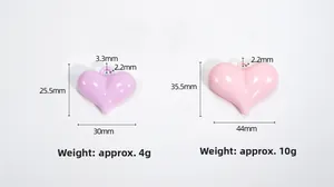 Detalle de colgantes de corazón color caramelo en morado y rosa con acabado brillante