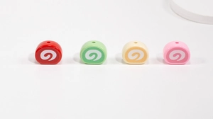 Macro shot of colorful Swiss roll beads in red, green, yellow and pink for DIY jewelry