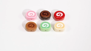 Detail of colorful swiss roll cake beads in six colors with spiral patterns for DIY