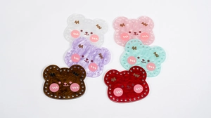 Macro view of six colorful acrylic bear charms with pre-punched holes for DIY bags