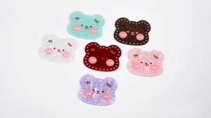 Macro detail of acrylic bear pendants with marble texture and pre-drilled sewing holes