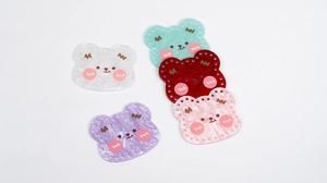 Macro detail of acrylic bear charms in five colors with pre-drilled holes for DIY crafts