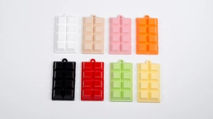 Detailed view of eight colorful miniature chocolate charms for keychains and DIY crafts