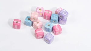 Close-up of colorful acrylic cube beads with engraved motivational text for DIY crafts