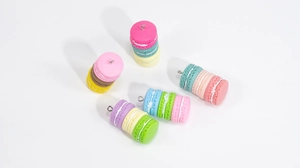 Close-up of colorful acrylic macaron cookie charms with metal hooks for DIY jewelry