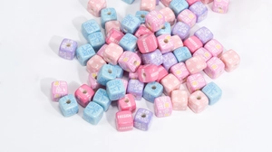 Close-up of colorful acrylic square beads with English letters and text for DIY crafts