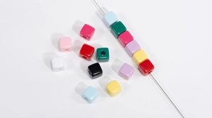 Macro-opname van kleurrijke vierkante acrylkralen met gaten voor DIY-sieraden maken