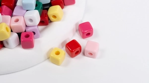 Macro-opname van kleurrijke vierkante acryl kralen met gaten voor DIY sieraden