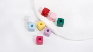 Close-up van kleurrijke vierkante acrylkralen met gaten voor DIY-sieraden maken