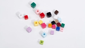Macro-opname van gekleurde acryl kubuskralen met middengat voor DIY-sieraden maken