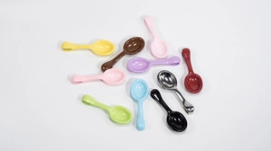 Macro shot of colorful mini spoon charms with hanging holes for DIY craft accessories
