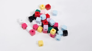 Macro-opname van kleurrijke vierkante acryl kralen met middengat voor DIY-sieraden
