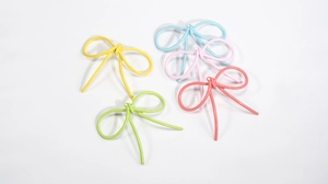 Dettaglio di cinque ciondoli a forma di fiocco colorati per accessori di gioielli DIY