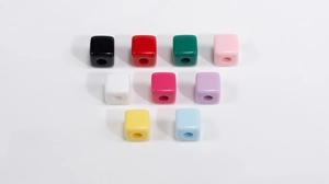 Detailopname van negen gekleurde acryl vierkante kralen met gaten voor DIY-sieraden maken