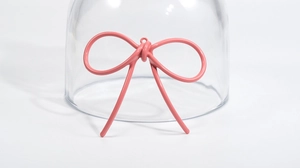 Dettaglio del ciondolo a fiocco rosa con finitura laccata opaca per gioielli DIY