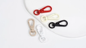 Detailed view of colorful alloy spring ring buckles on a minimalist display tray