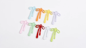 Macro view of colorful alloy bowknot pendants with vibrant enamel finish for DIY jewelry