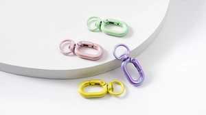 Close-up of pearl-finish metal spring buckles in pastel green, pink, purple, and yellow