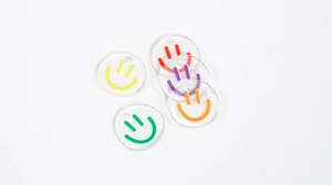 Macro shot of colorful acrylic smiley face charms with top holes for DIY jewelry