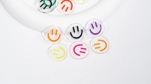 Macro shot of colorful smiley face charms in clear acrylic for DIY jewelry making