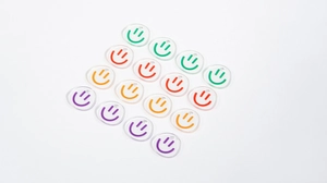 Detail of colorful smiley face acrylic charms for DIY keychains in a transparent finish