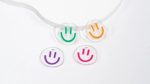 Macro shot of 4-pack colorful acrylic smiley face charms for DIY jewelry and keychains