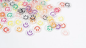 Macro detail of transparent acrylic smiley face pendants with pre-drilled hanging holes