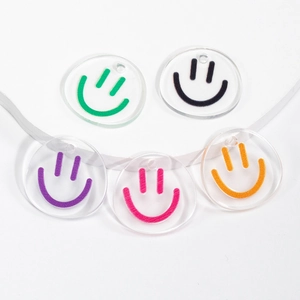 Five round clear acrylic smiley face charms in green black purple pink and orange