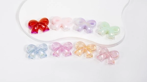 Close-up of colorful pearlescent bow beads with glitter finish for DIY jewelry crafts
