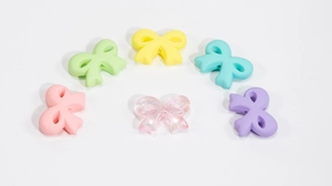 Close-up of matte and glittery acrylic bow beads for DIY jewelry and phone chain making