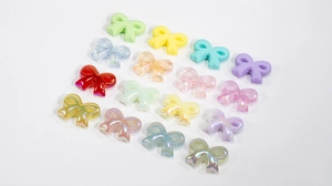 Close-up of assorted frosted and glitter acrylic bow beads for DIY crafts making