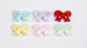 Close-up of colorful 3D acrylic bow beads with pearlescent finish for DIY jewelry