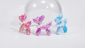 Detail of colorful acrylic balloon dog charms with pearl collars in pink, purple and blue