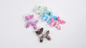 Detail of colorful pearlescent acrylic balloon dog charms with pearl collars for DIY crafts